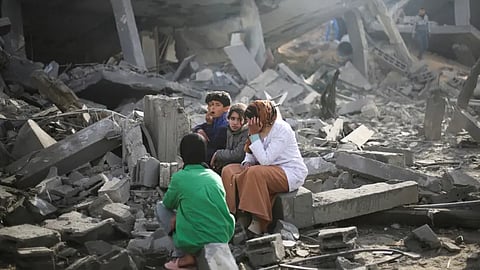 عائلة تجلس على حطام منزلهم في مدينة رفح جنوب قطاع غزة