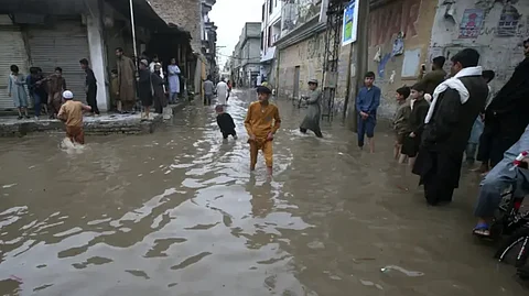 باكستانيون في شارع غمرته الأمطار الغزيرة في بيشاور