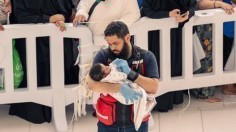 متطوع بجمعية غوث يقوم برعاية طفل في الحرم المكي