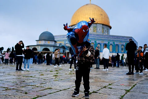 طفل يحمل بالونًا ابتهاجًا بقدوم العيد في ساحة المسجد الأقصى بالقدس المحتلة