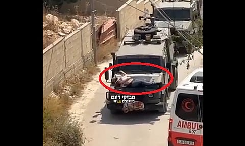 على مقدمة مركبة عسكرية.. شاهد لحظة تنكيل جيش الاحتلال بشاب فلسطيني جريح