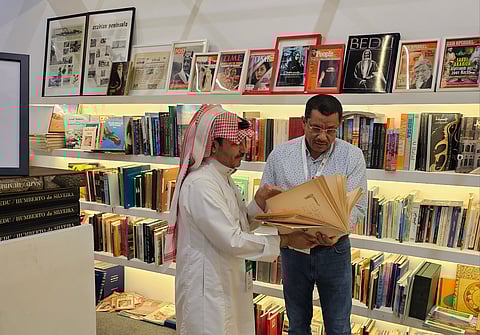 عبدالله المتعب يطلع المحرر على نسخة غير مستعملة من كتاب بطل الجزيرة