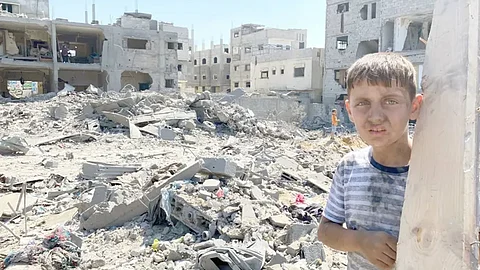 أرشيفية لطفل فلسطيني أمام مبان مدمرة بفعل الغارات الإسرائيلية على حي الصبرة في غزة