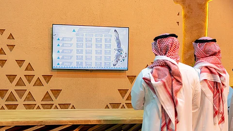 شاشات عرض تُظهر مجريات المبيعات بالمزاد الدولي لمزارع إنتاج الصقور
