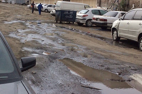 بالصور.. طفح "الصرف" يختلط بالمخلفات وهياكل السيارات بـ"معارض الطائف"