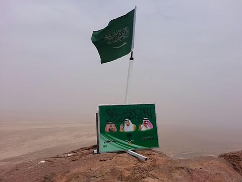 "نواف النافل" يرفع العَلَم وصور القيادة على "عجاجان" بحائل