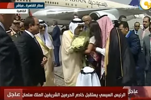أطفال يستقبلون خادم الحرمين بالورود في مطار القاهرة