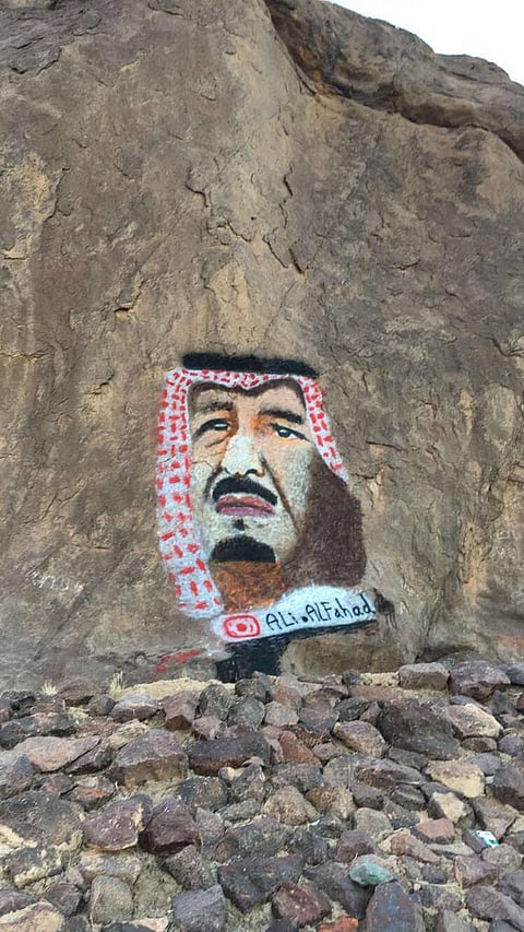 شاب يعبّر عن حبه لخادم الحرمين برسم صورته على جبل أجا بحائل