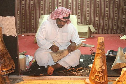 أنامل ذهبية نقشت الأخشاب وزخرفت الخط العربي وخاطت السدو في سوق عكاظ