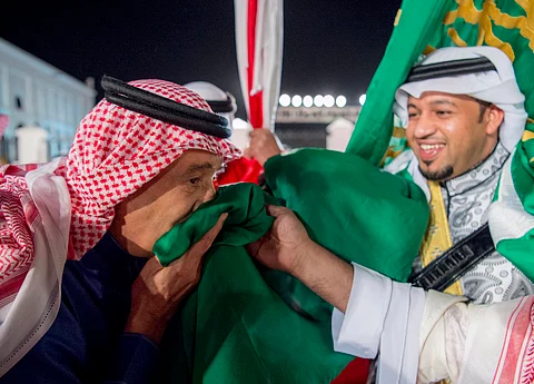 شاهد.. الملك "سلمان" يتفاعل مع العرضة ويقبِّل العَلَمَيْن السعودي والبحريني