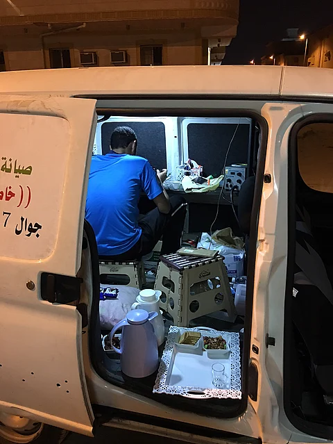 شاهد .. شابان سعوديان يعملان على صيانة الجوال بمركبتيهما