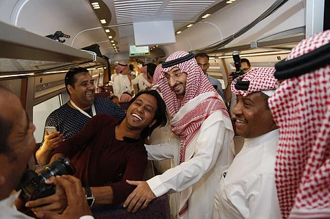 بالصور.. فرحة مشتركة بين "عبدالله بن بندر" والشباب على متن قطار الحرمَيْن