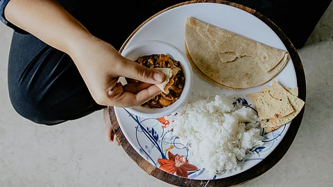 Person Eating Indian food rice and chappati