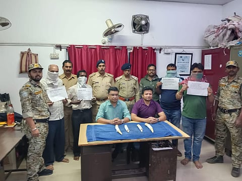 हाथी के दांत के साथ पकड़े गये तस्करों को दिखाते हुए वाइल्ड लाइफ क्राइम कंट्रोल ब्यूरो के अधिकारी