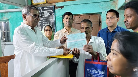 सुंदरवन विकास मामले के मंत्री बंकिम चंद्र हाजरा चेक सौंपते हुए