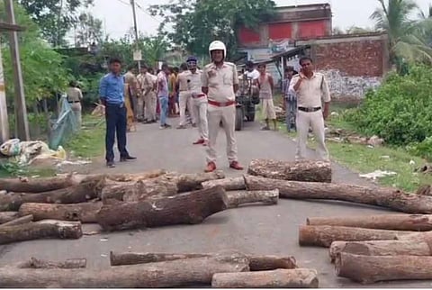 सड़क पर पेड़ के तने फेंक कर विरोध प्रदर्शन करते स्थानीय लोगों को समझाते हुए पुलिस