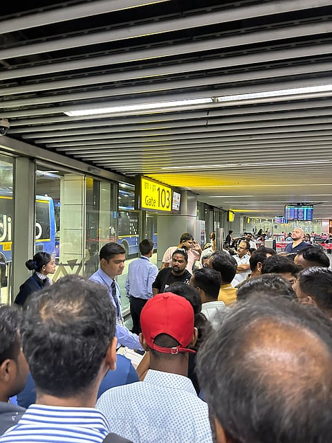 एयरपोर्ट पर बोर्डिंग के पास खड़े यात्री