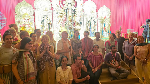 विदेशी पर्यटक कोलकाता में दुर्गापूजा के दौरान पंडाल में घूमते हुए