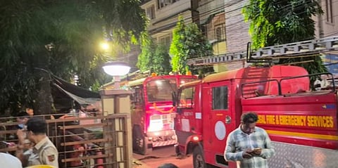 Fire engines at the scene, people extinguishing the fire and firefighters