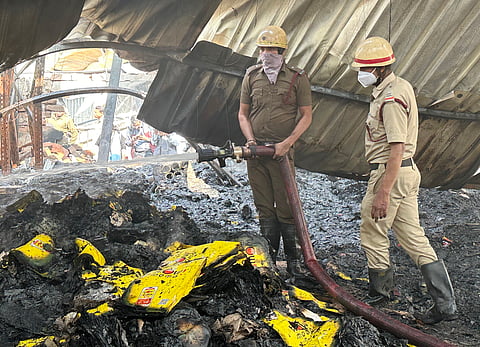 मंगलवार की दोपहर नजीराबाद में आग बुझाते हुए दमकल कर्मी