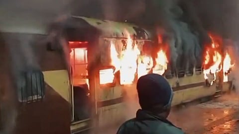 कटवा स्टेशन के प्लेटफॉर्म पर खड़ी लोकल ट्रेन में लगी आग।