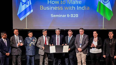 हस्ताक्षारित दस्तावेजों को दिखाते भारत और इजराइल के अधिकारी।