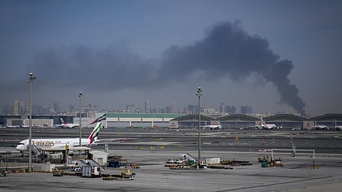 दुबई एयरपोर्ट के निकट ईरानी हमले से उठता धुआं और रुके पड़े विमान।