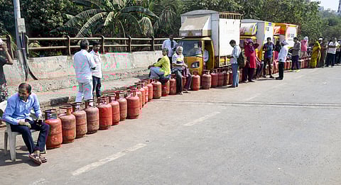 मुंबई में गैस सिलेंडरों के साथ लाइन में लगे लोग।