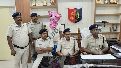 हथियार के साथ गिरफ्तार अभियुक्त को पुलिस अधिकारी दिखाते हुए