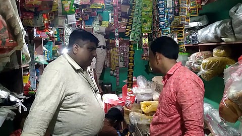 दुकान में छापामारी करती आबकारी विभाग की टीम