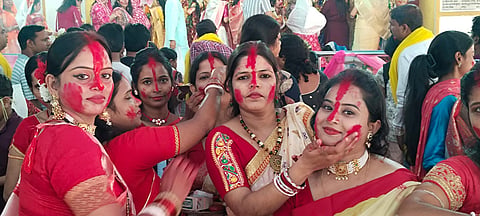 एक - दूसरे को सिंदूर लगाती महिलाएं