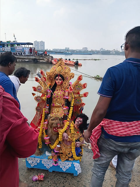 बाजेकदम तला घाट पर मां दुर्गा की प्रतिमा विसर्जन करते लोग