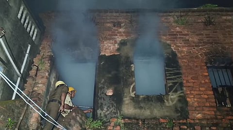 मकान में लगी आग को बुझाते दमकल कर्मी