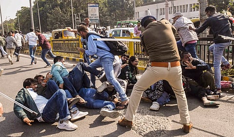 पटना में बीपीएससी कार्यालय के बाहर प्रदर्शनकारी अभ्यर्थियों पर लाठीचार्ज करते पुलिस अधिकारी।