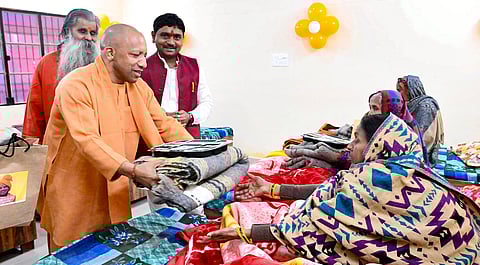 गोरखपुर में लोगों में वस्त्र वितरण करते सीएम योगी आदित्यनाथ।