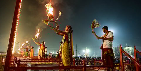 प्रयागराज में संगम पर गंगा आरती करते महिला बटुक के साथ पुजारी।