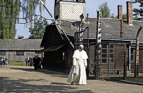 Pope Francis walks through the gate of the former Nazi German death camp of Auschwitz in Oswiecim, Poland, Friday, July 29, 2016.  Pope Francis paid a somber visit to the Nazi German death camp of Auschwitz-Birkenau Friday, becoming the third consecutive pontiff to make the pilgrimage to the place where Adolf Hitler's forces killed more than 1 million people, most of them Jews. (AP Photo/Gregorio Borgia)