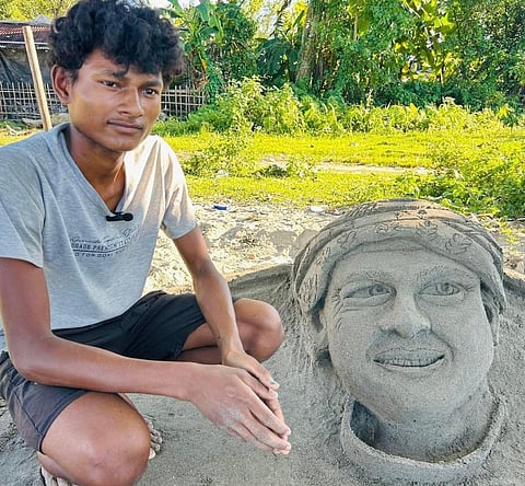 Image Of the sand artist Akash Karmakar alongside the Sculpture of Late Zubeen Garg