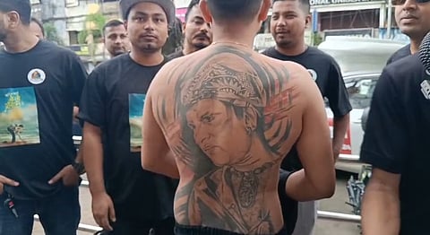 Image of a fan revealing Zubeen Garg's portrait on his back in Dibrugarh