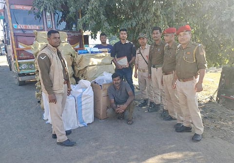 Image of the arrested individual with the large packs of illicit foreign cigarettes