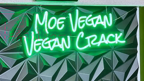 The neon "Vegan Crack" sign lights up the counter at Moe Vegan, the new South Seattle restaurant redefining soul food with a plant-based approach.