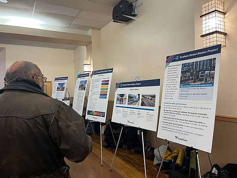 A person looks over a row of easels with informational material on them.