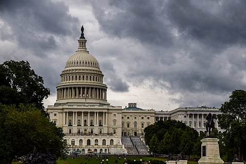 The outside of the U.S. Capitol Building against a cloudy, stormy-looking sky.
