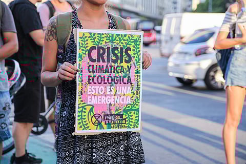 Buenos Aires, Argentina; March 3, 2023: Global Climate Strike. Unrecognizable woman holding a poster: Climate and ecological crisis. This is an emergency.