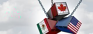Three suspended shipping containers colliding in mid-air, each painted with the national flag of a North American country: Canada, Mexico, and the United States.