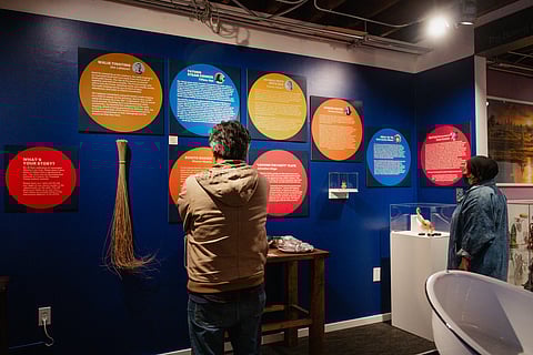 Visitors check out objects on display at Shin Yu Pai's "Ten Thousand Things" exhibition at the Wing Luke Museum.