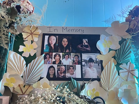 Dried and paper flowers a leaves adorn a plaque featuring photos of people. "In Memory" is inscribed at the top.
