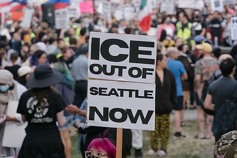 Immigration protest in Seattle with sign demanding “ICE Out of Seattle Now” during anti-ICE rally advocating immigrant rights and ending mass deportations.