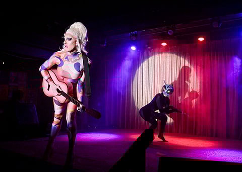 Betty Wetter (left) and Stasia Coup perform at Tush! in April. Betty Wetter is holding a guitar and Stasia Coup is dressed as an insect.