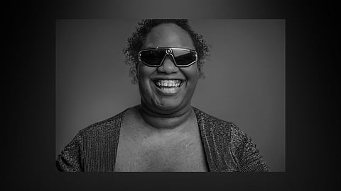 A headshot of Brittany Davis wearing glasses and smiling widely at the camera.